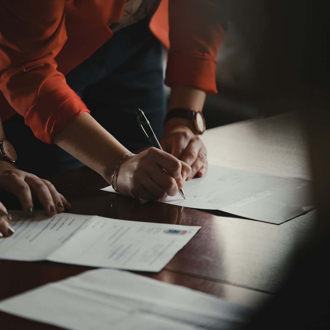 hands signing a document