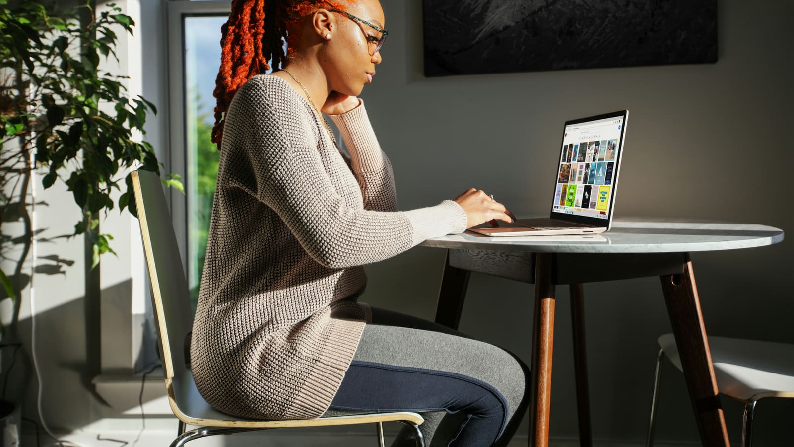 a desk by a window, the screen in use